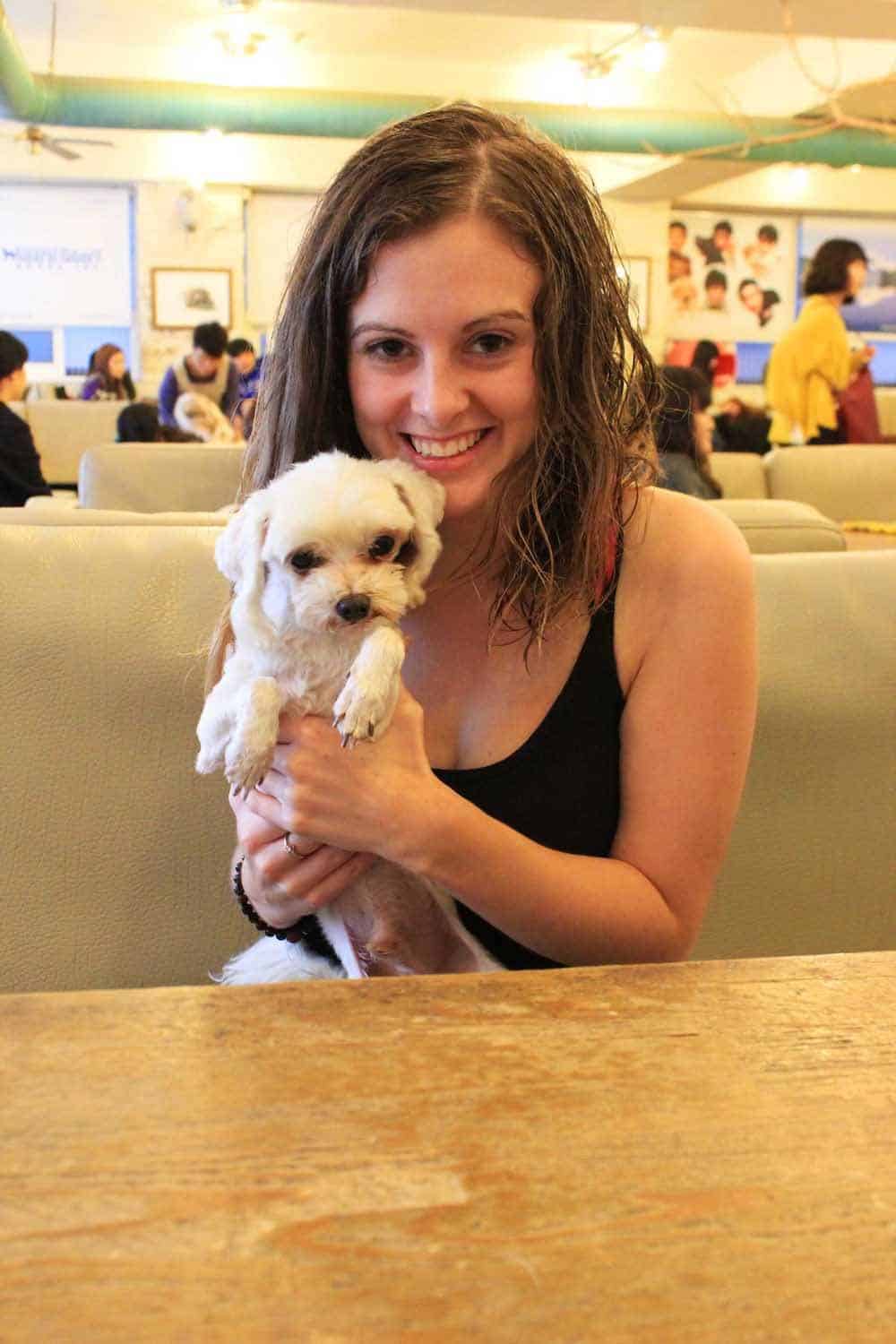 girl holding a dog at a dog cafe