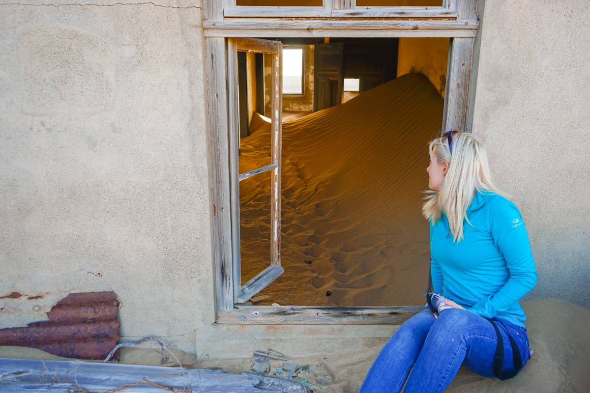 Girl looking into a window at Kolmanskop