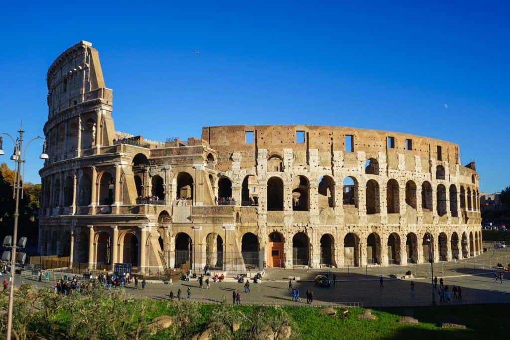 Outside the Colosseum in Rome, with people waiting to enter and walking around nearby.