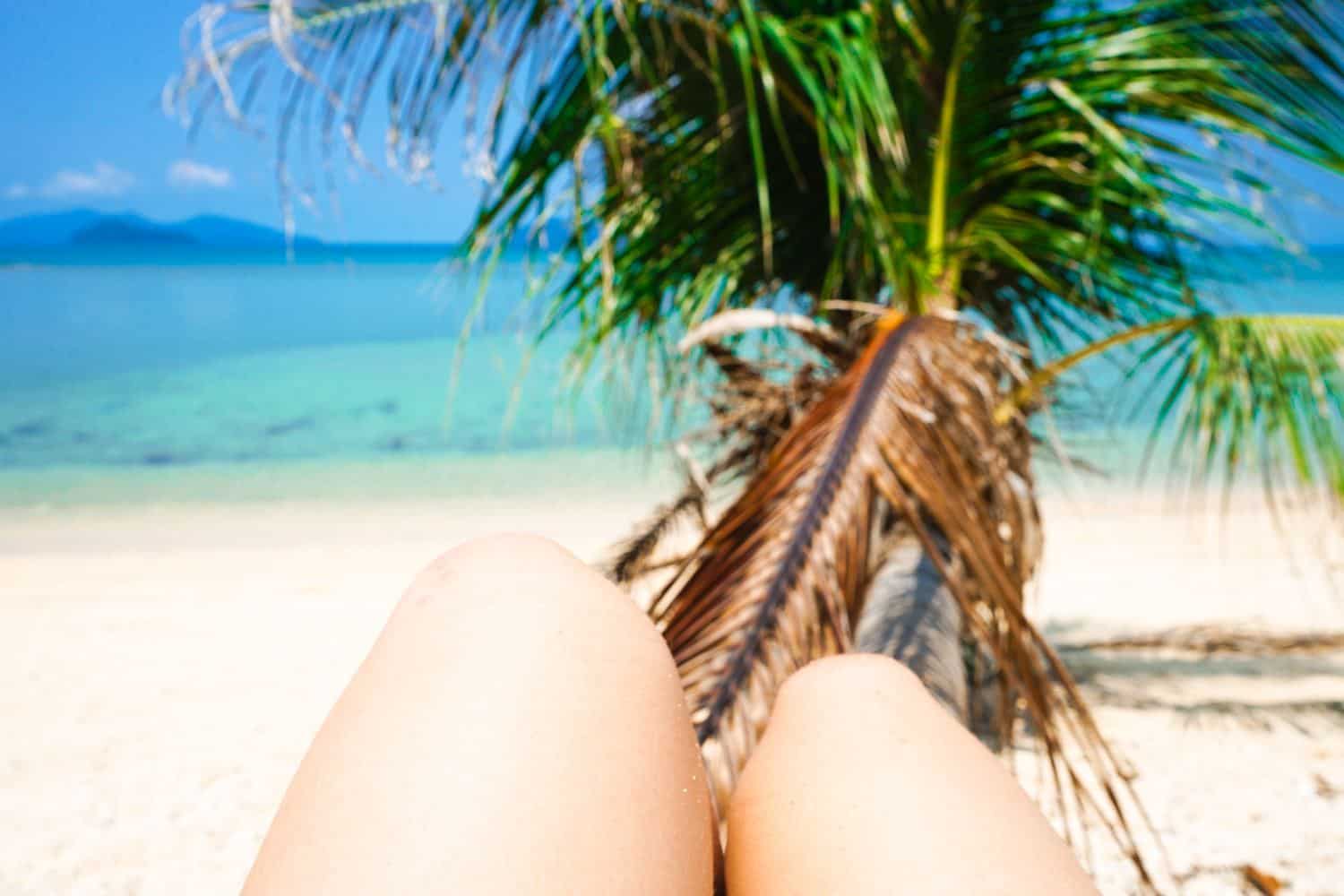 Legs on a palm tree by the sea