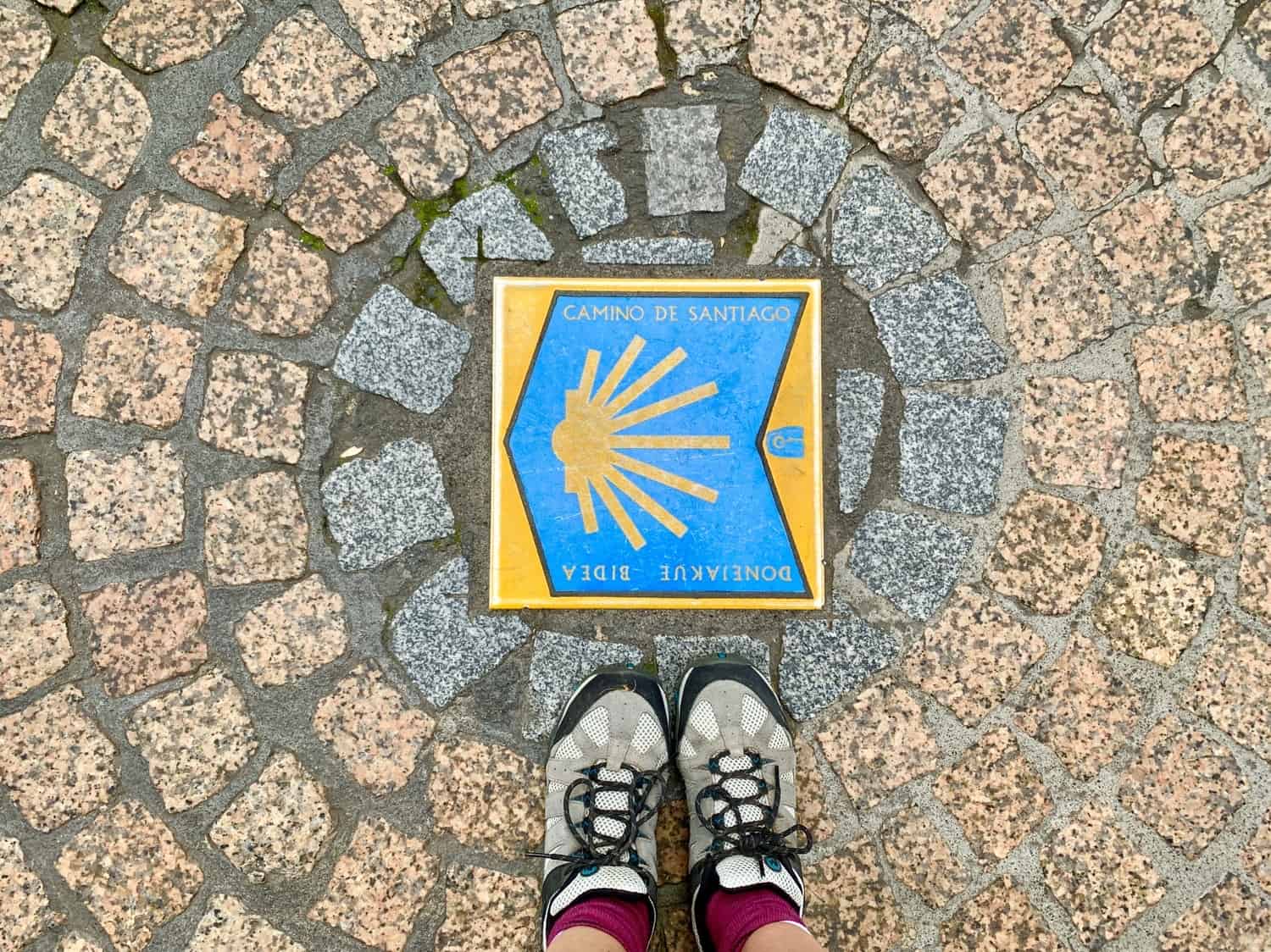 Hiking shoes with Camino sign on the ground