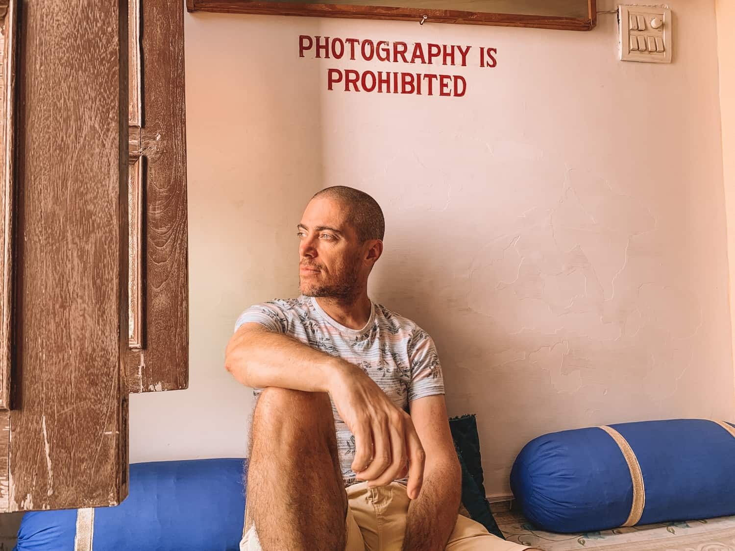 Man underneath sign saying photography is prohibited