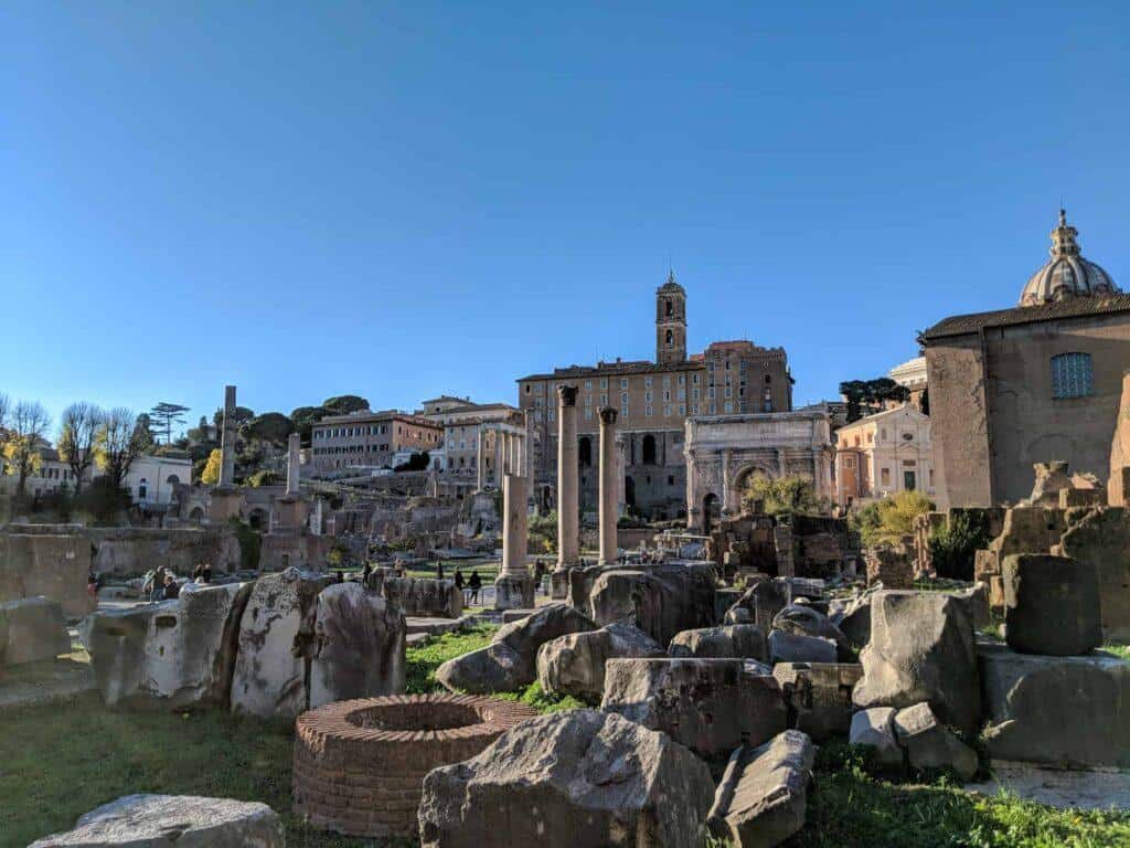 Stone and marble ruins at the Roman Forum, spread over a wide area.