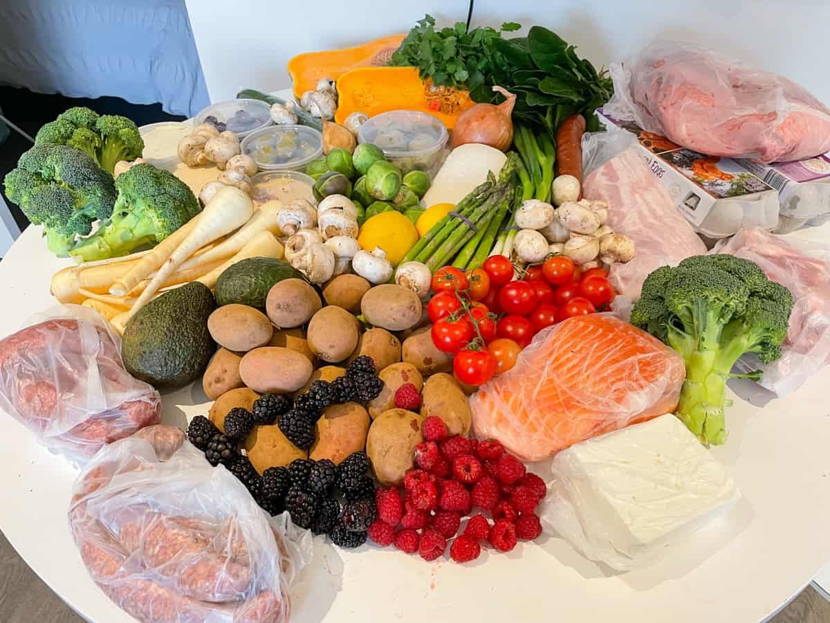 A weekly grocery shop from the Queen Vic Market spread out across a kitchen table. It's entirely whole foods; mostly vegetables, with some fruits and fresh meat