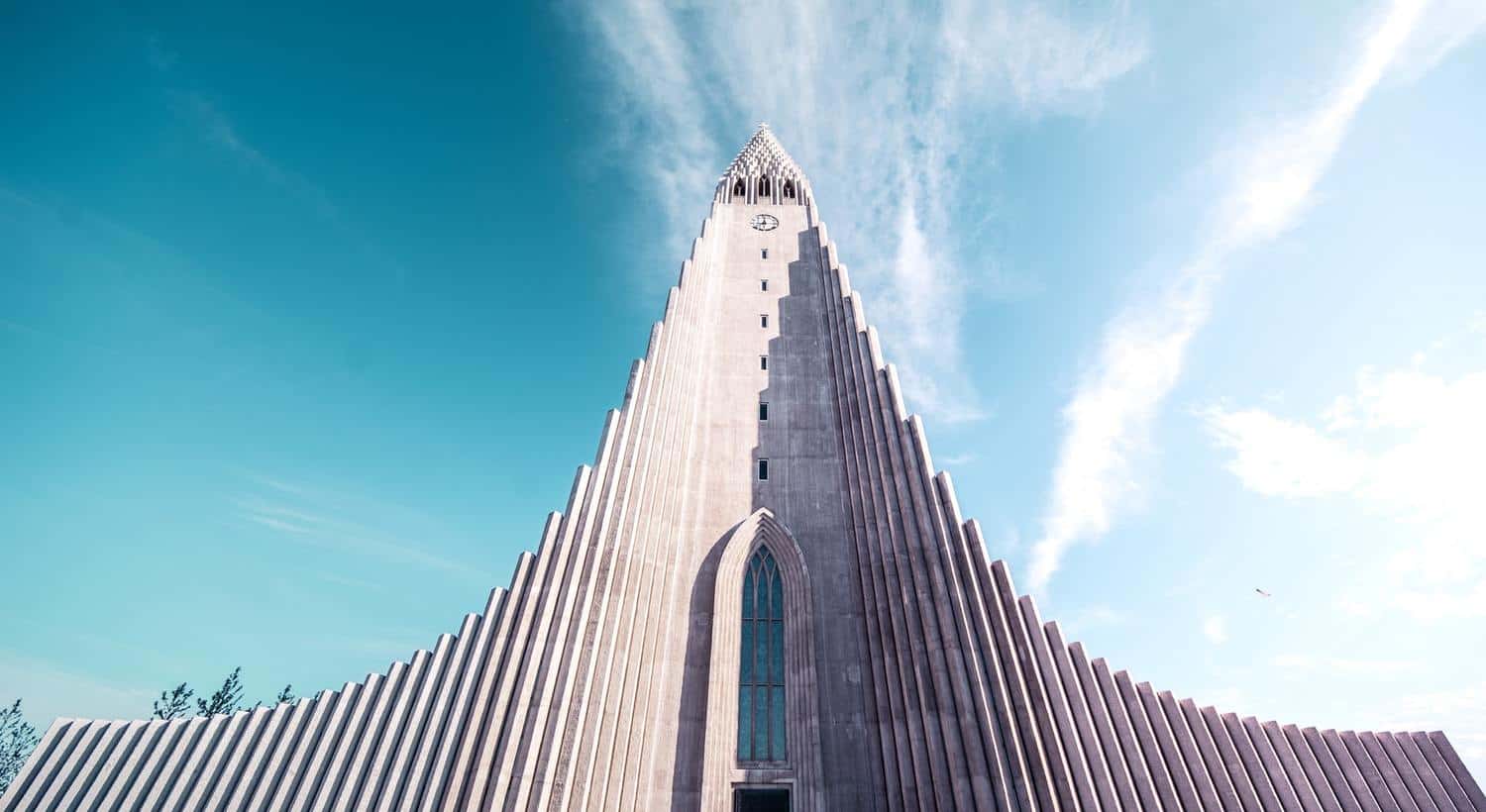 A dramatic stepped concrete church in Iceland, raising up to a steeple at the top.
