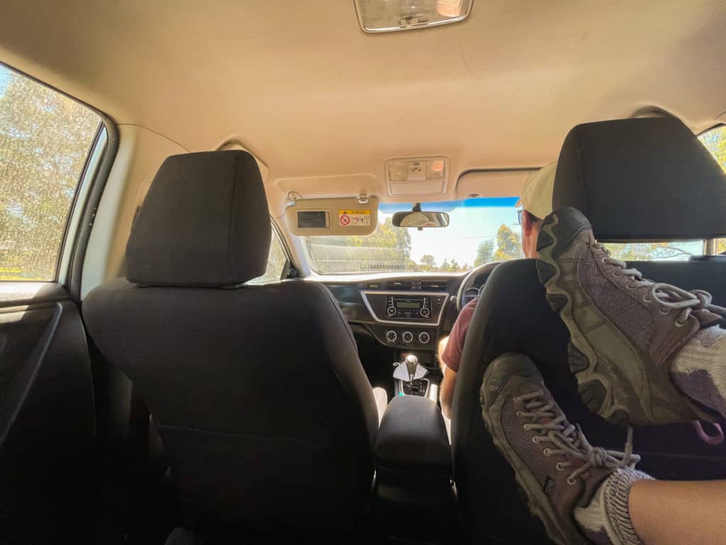Lauren's legs raised in the air in the backseat of the car.