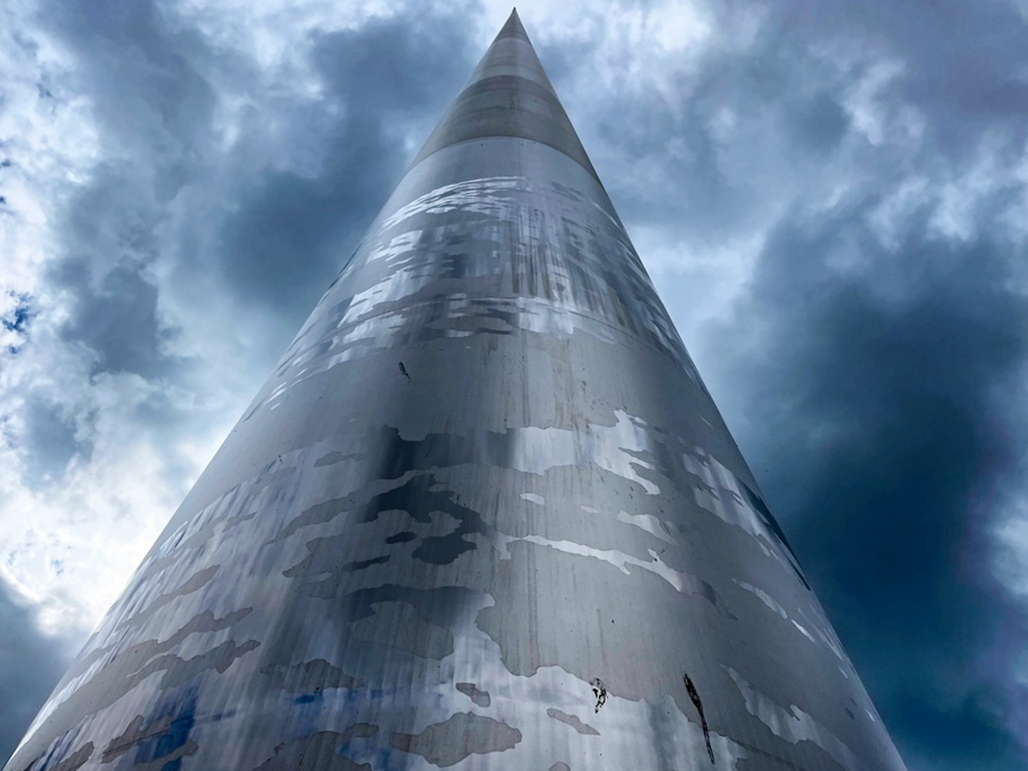 An ominous looking scene, depicting the Spire of Dublin pointing directly towards the sky. From the close-up angle, it looks as though the spire travels upwards for miles. 